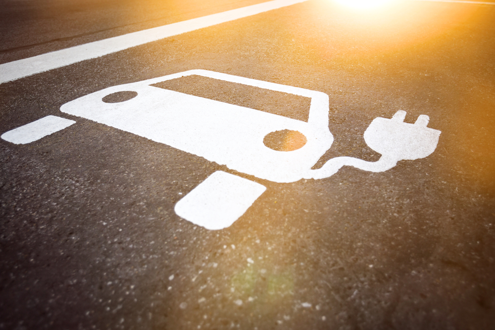 Stencil on road surface of a car with a plug